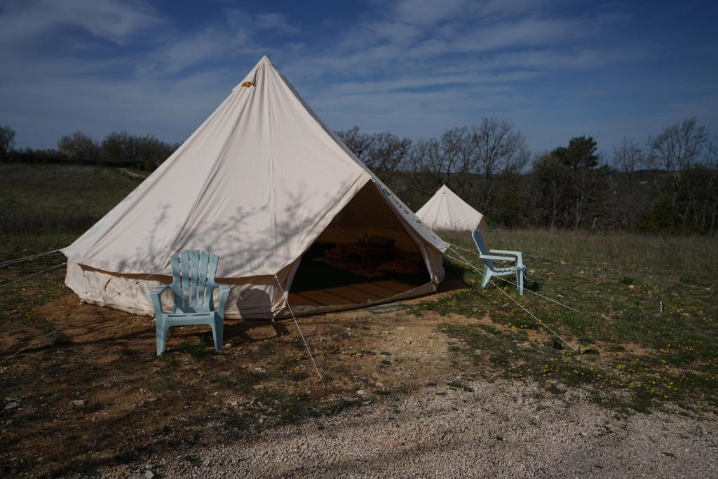 two chairs and a tent in a field at Camping Arbre de Vie in Montagnac