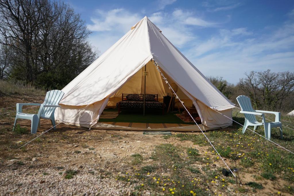a tent with two chairs and a table at Camping Arbre de Vie in Montagnac