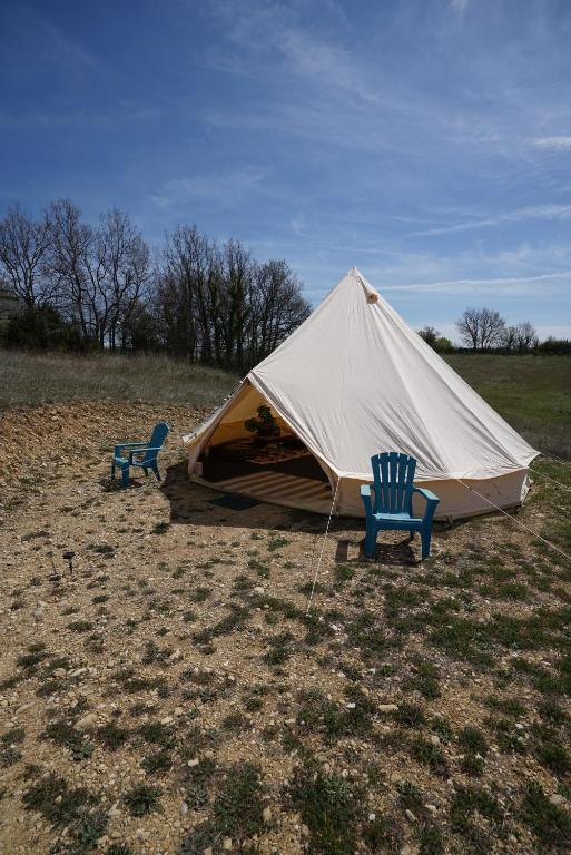 two chairs and a tent in a field at Camping Arbre de Vie in Montagnac