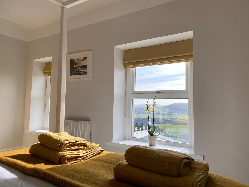 a bedroom with a bed with two pillows and a window at Llandudno Boutique style seaside retreat with stunning views in Llandrillo-yn-Rhôs