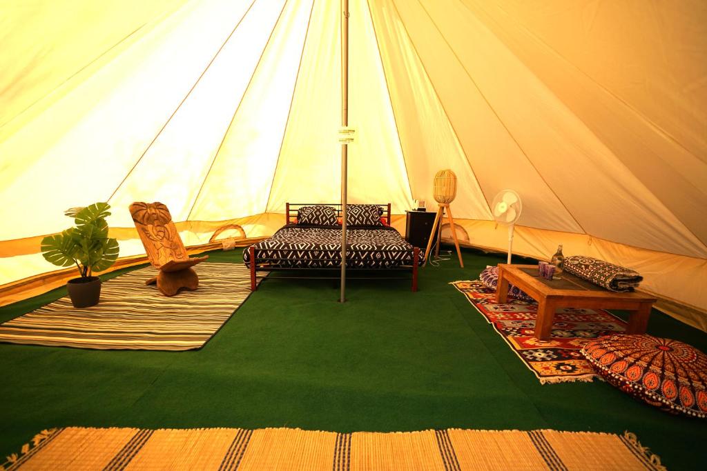 a tent with a couch and chairs and a table at Camping Arbre de Vie in Montagnac