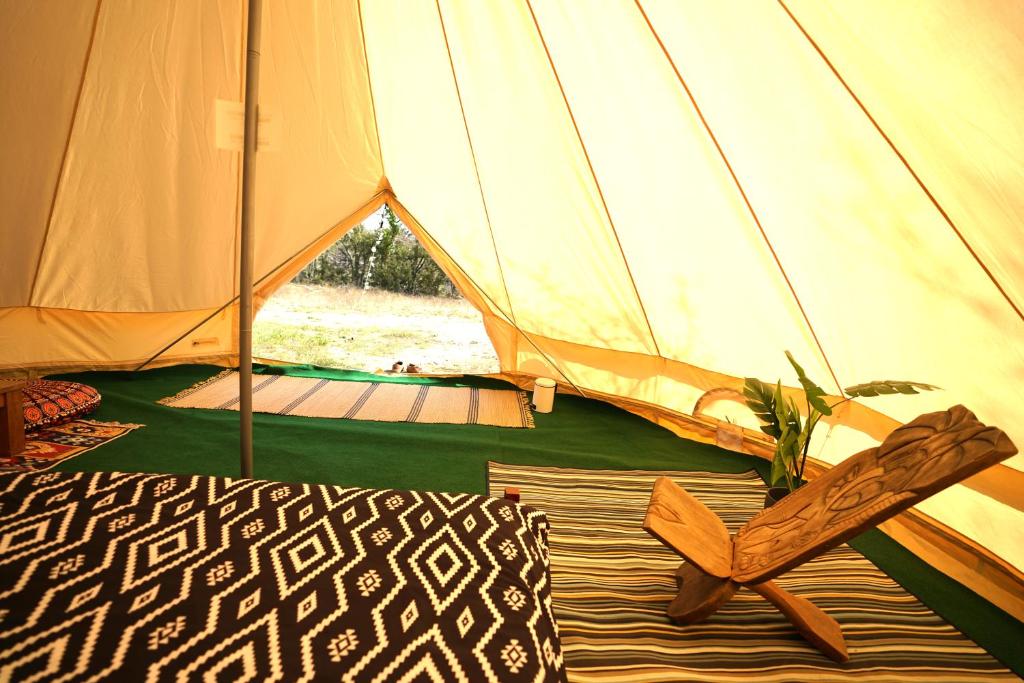 a tent with a pair of shoes in front of it at Camping Arbre de Vie in Montagnac