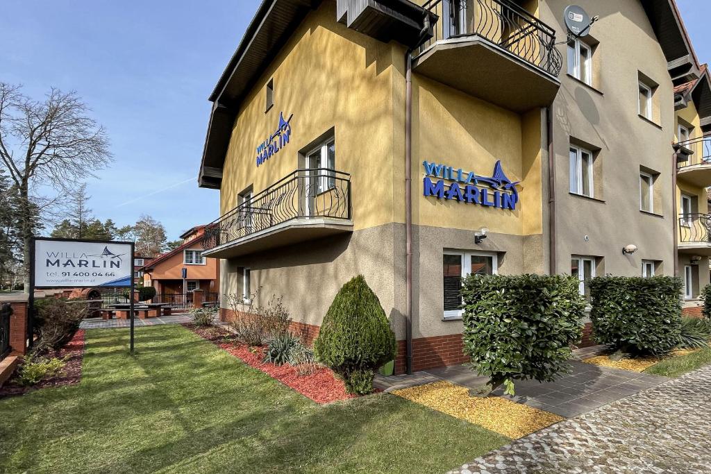 a building with a sign on the side of it at Willa Marlin in Pobierowo