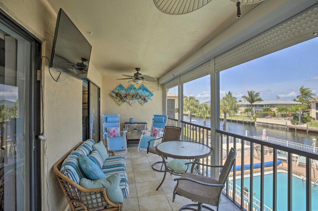 a balcony with a table and chairs and a view of the water at Pool and Canal Access Central Cape Coral Condo! in Cape Coral