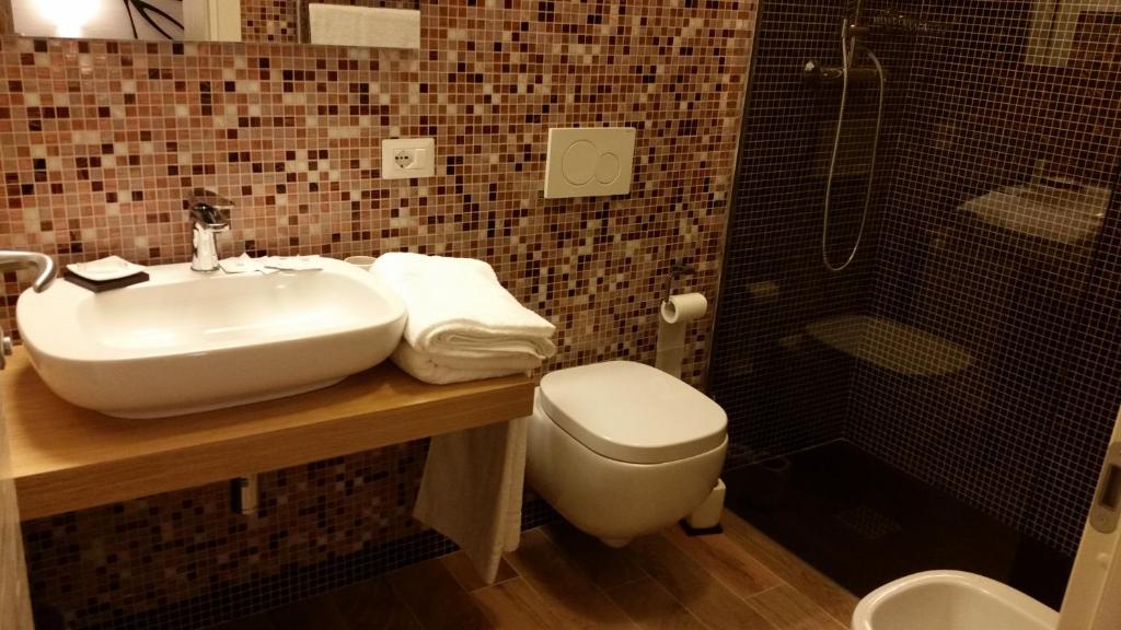 a bathroom with a sink and a toilet and a shower at Casa Mafalda in Chioggia