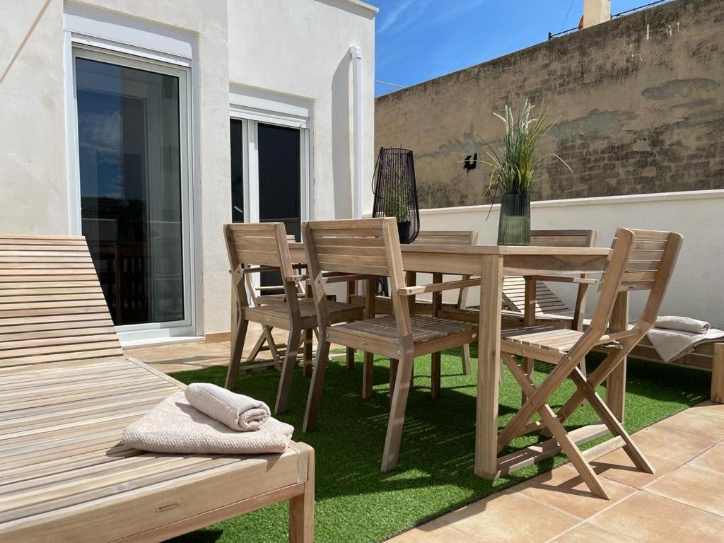 einen Holztisch und Stühle auf einer Terrasse in der Unterkunft UIM Mediterraneo CASA Plomo Wifi in Puerto de Sagunto