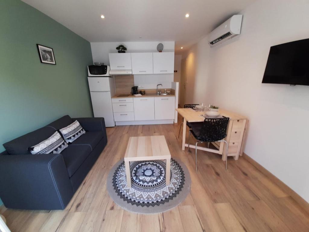 a living room with a couch and a table at Appartement neuf de 30 m2 au coeur de palavas Classé 2 étoiles in Palavas-les-Flots