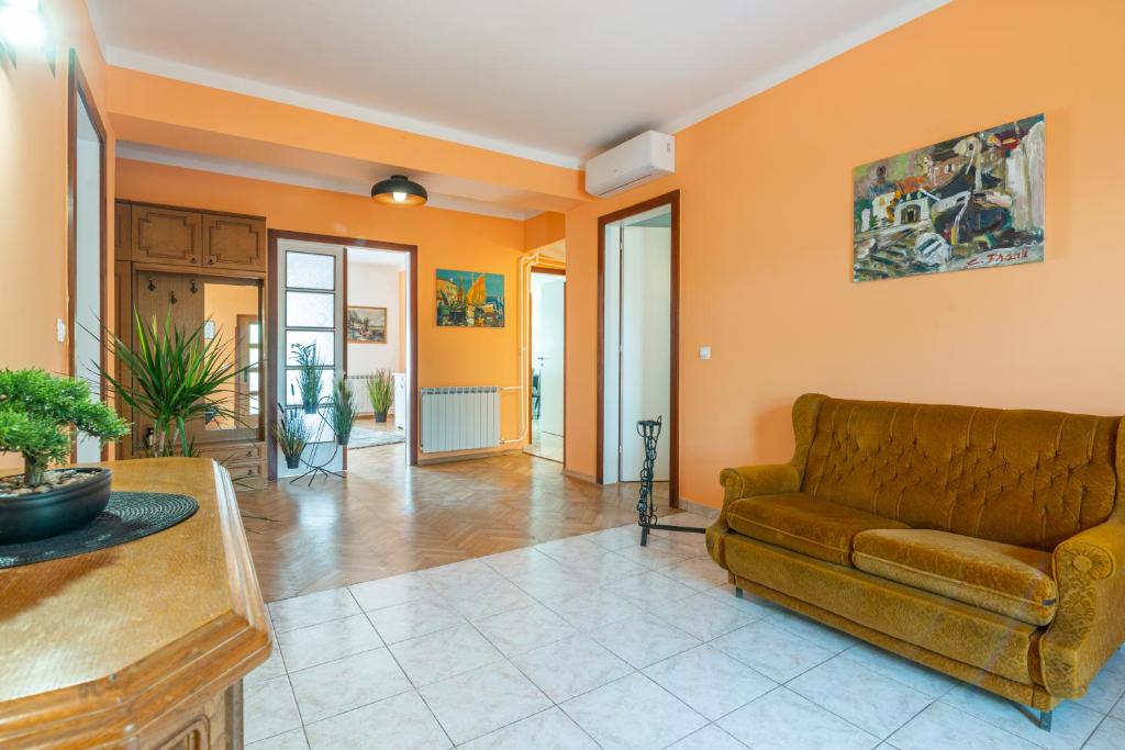 sala de estar con sofá y paredes de color naranja en Apartments Virna en Opatija