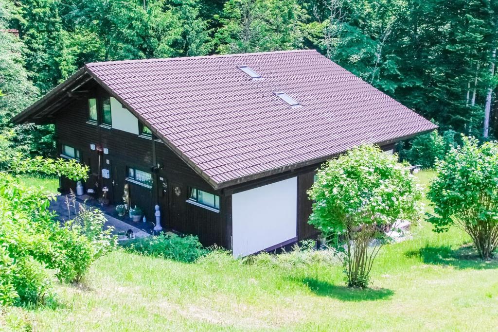 een klein huis met een garage in een veld bij Geographer´s Cottage in Siegsdorf