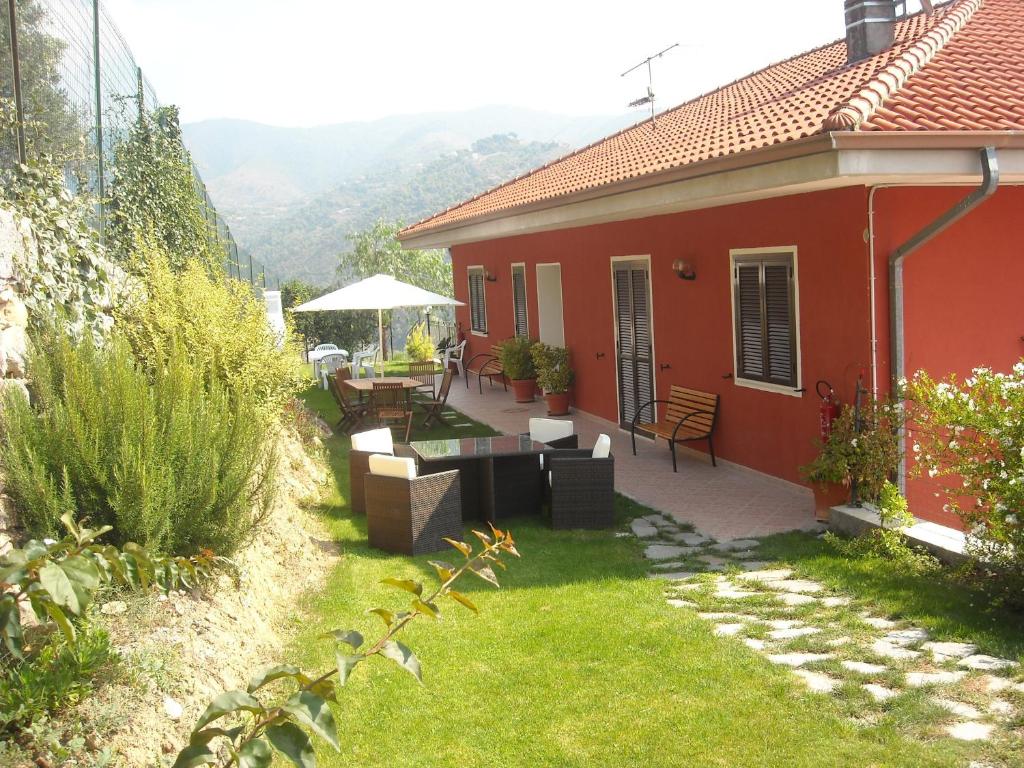 una casa roja con una mesa y sillas en un patio en Agriturismo da Luì, en Bordighera