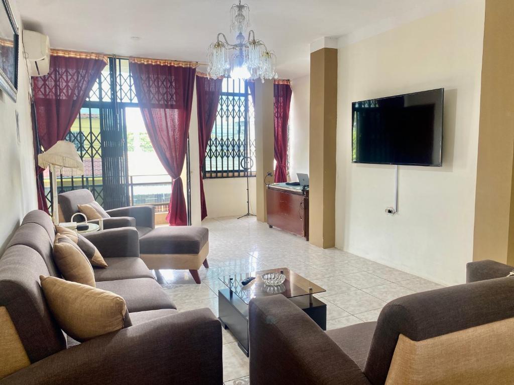 ein Wohnzimmer mit Sofas und einem Flachbild-TV in der Unterkunft Departamento familiar & empresarial in Machala