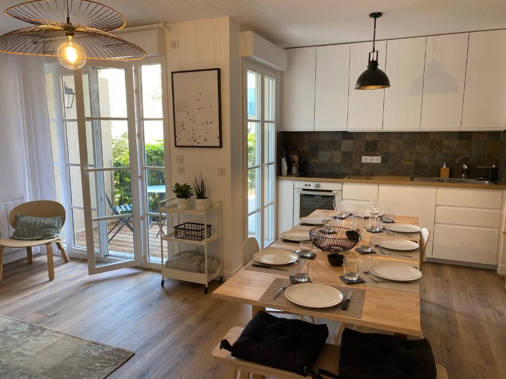 uma cozinha com uma mesa de madeira com placas em La Serrisienne 5 - Val d'Europe - Disneyland Paris - 6 à 8 Personnes em Serris