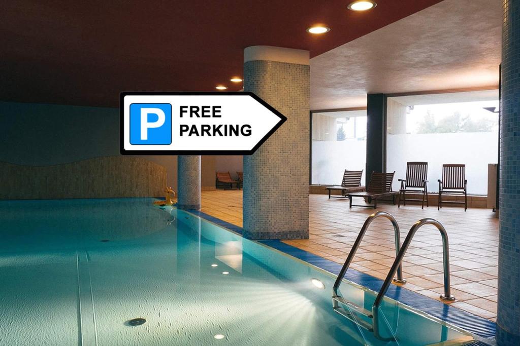 een bord met gratis parkeren naast een zwembad bij Grey Apartment Kołowa in Krakau