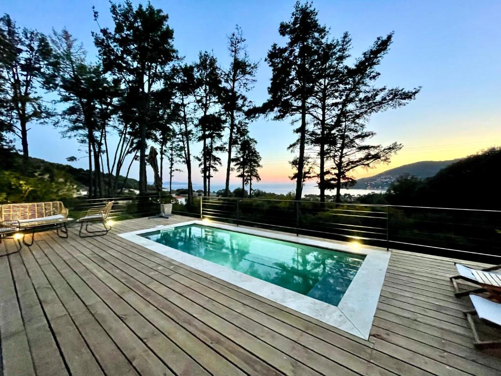 サゴーヌにあるVilla piscine Sagone Paradise avec magnifique vue merの木製デッキ上のスイミングプール