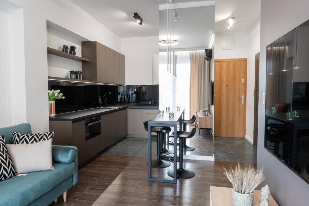 a kitchen with a couch and a table in a room at Apartamenty DES-Zator in Zator