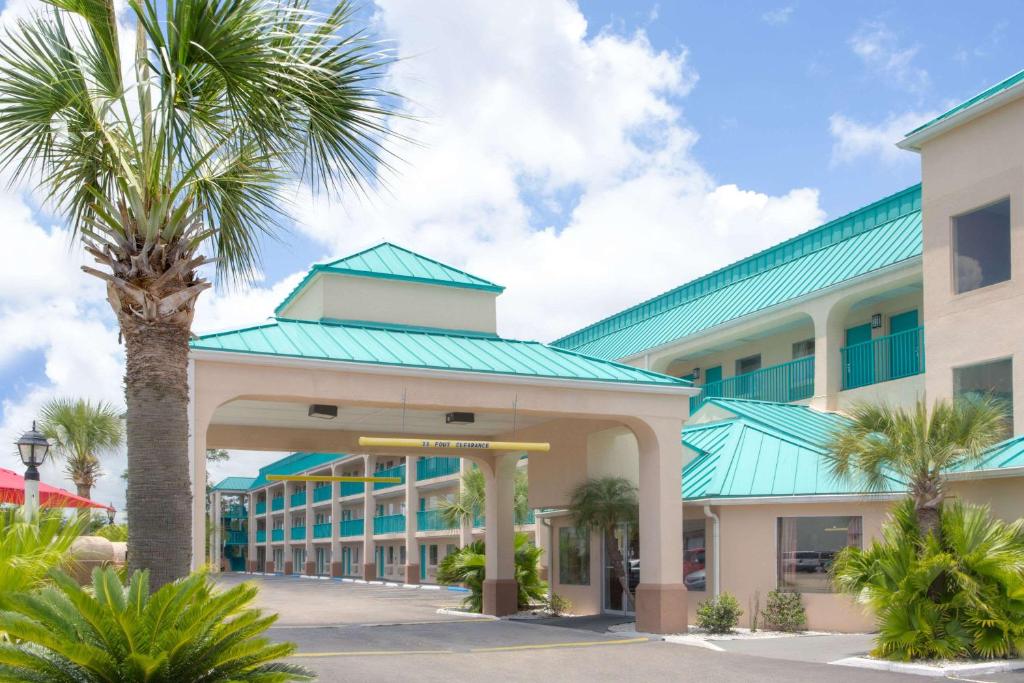 a palm tree in front of a building at Days Inn by Wyndham Gulfport in Gulfport