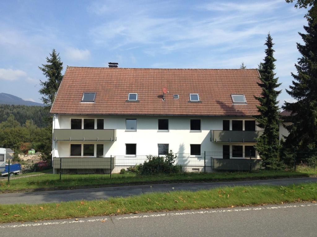 ein großes weißes Haus mit rotem Dach in der Unterkunft Harzidyll Living Apartements in Braunlage