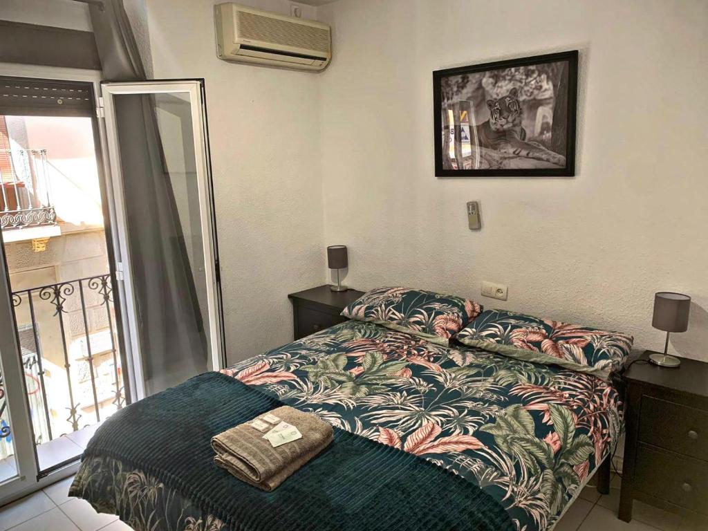 a small bedroom with a bed and a balcony at Barbieri Granada Pensión in Granada