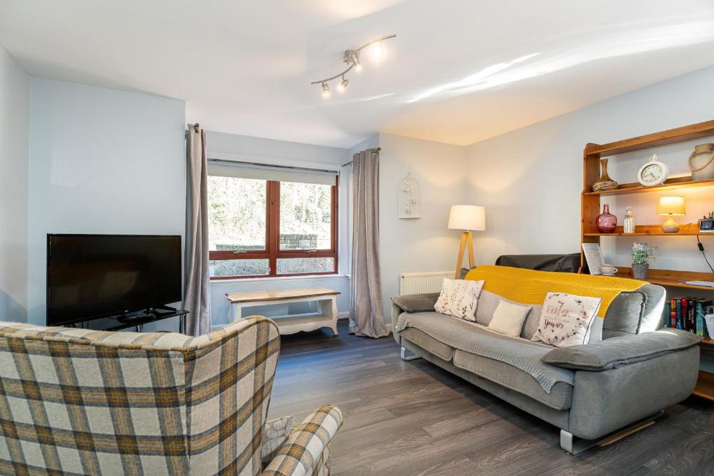 un soggiorno con divano e TV di One Bedroom ground floor flat a Stirling
