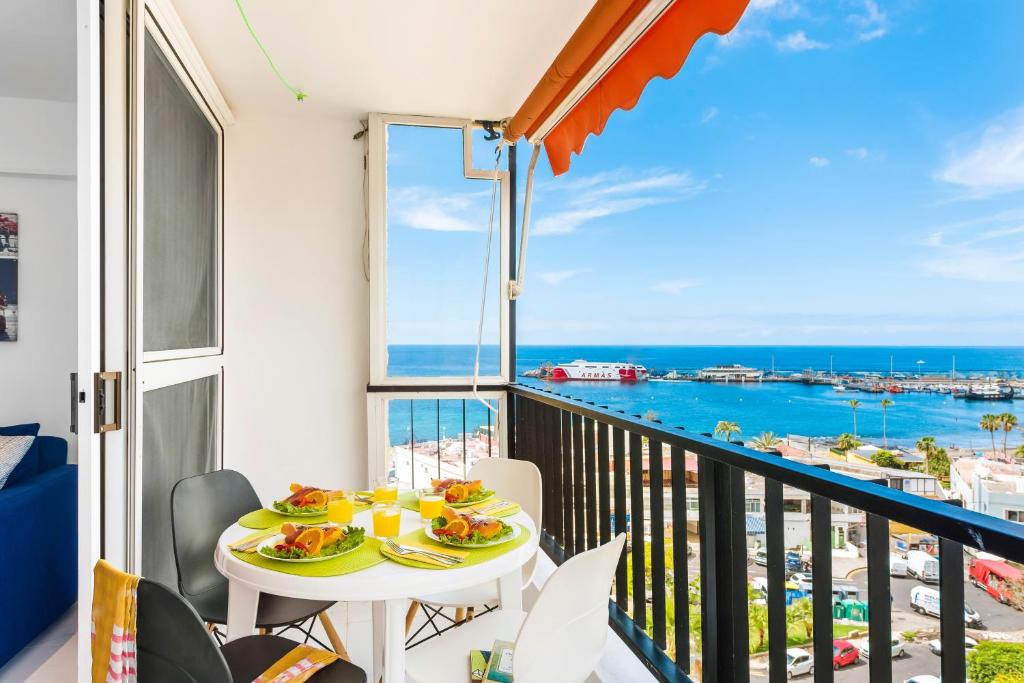 d'un balcon avec une table et des chaises et une vue sur l'océan. dans l'établissement 76. Los Cristianos first sea line, parking, Wi Fi, à Los Cristianos