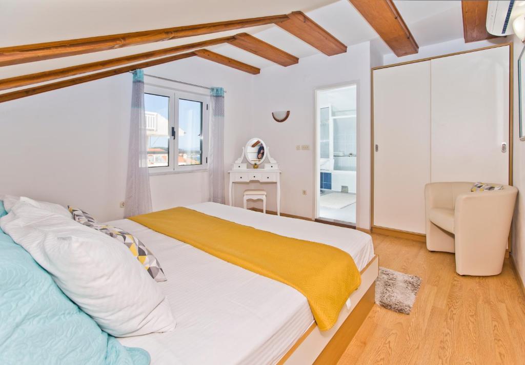 a bedroom with a large bed with a yellow blanket at Apartmani Marinka Viskovic in Hvar