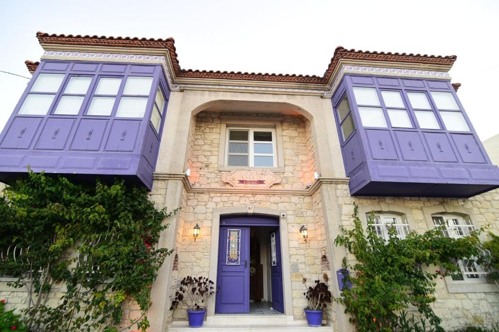 a house with a purple door and windows at Mor Salkım Konağı in Alaçatı