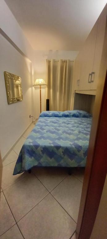 a bedroom with a bed with a blue comforter at Casa Anna in Gioiosa Marea