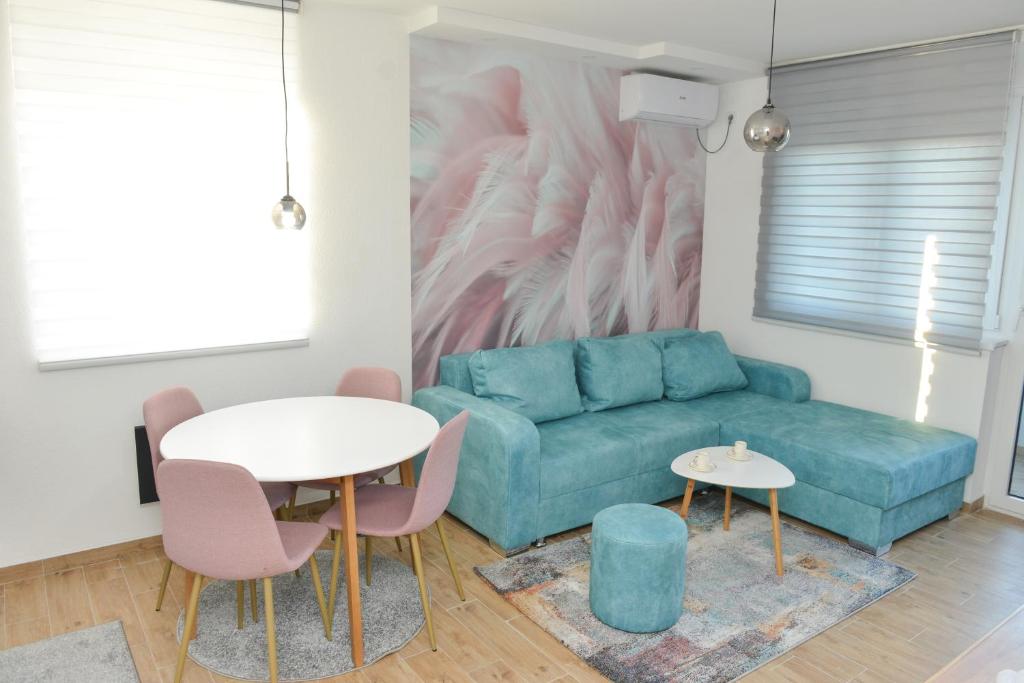 a living room with a blue couch and a table at Apartmani Martenovic 1 in Vrnjačka Banja