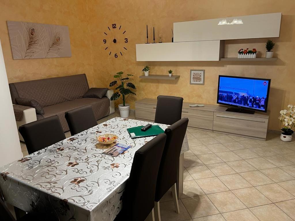 a living room with a table with chairs and a television at IL RIFUGIO DEL RE in Pisticci
