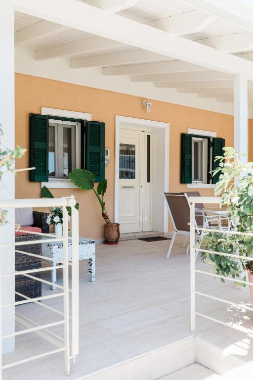 a porch with green shutters and plants at Matoula's House in Nydri
