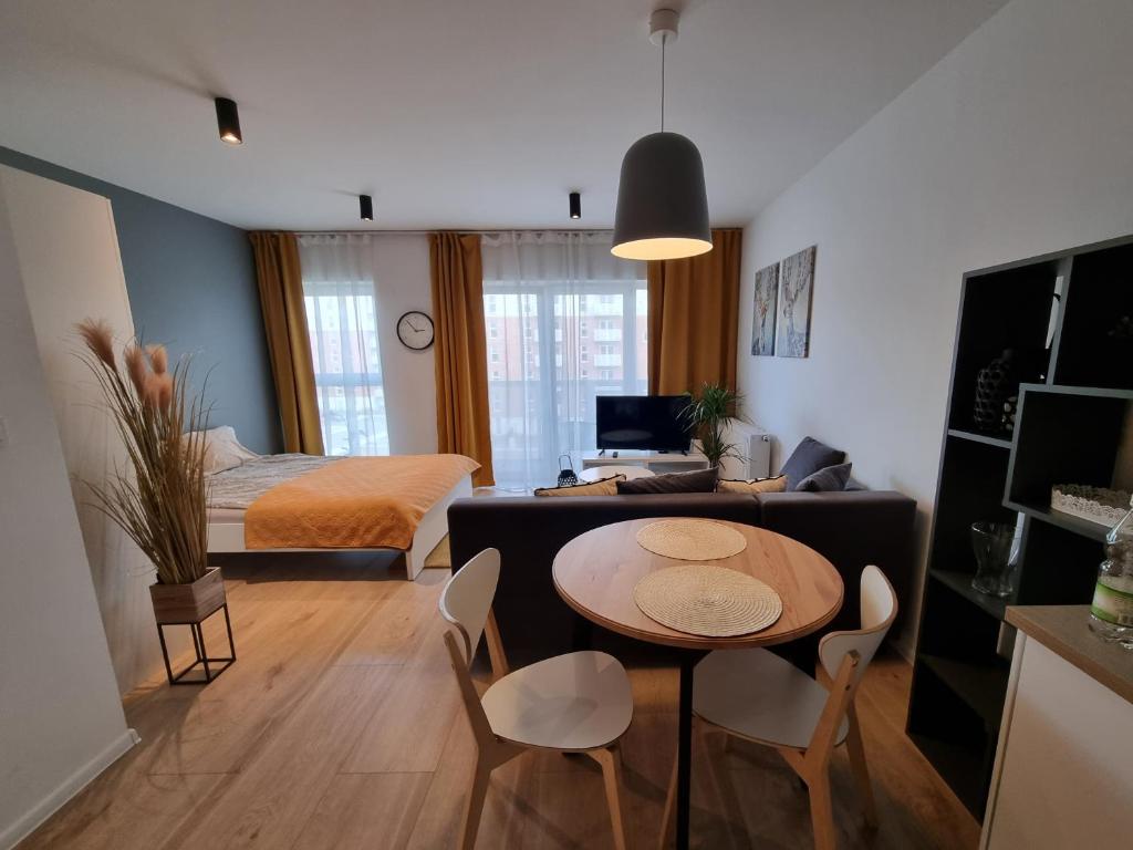 salon ze stołem i sypialnia w obiekcie Apple Apartments - Wróblewskiego PRYWATNE MIEJSCE PARKINGOWE w Łodzi