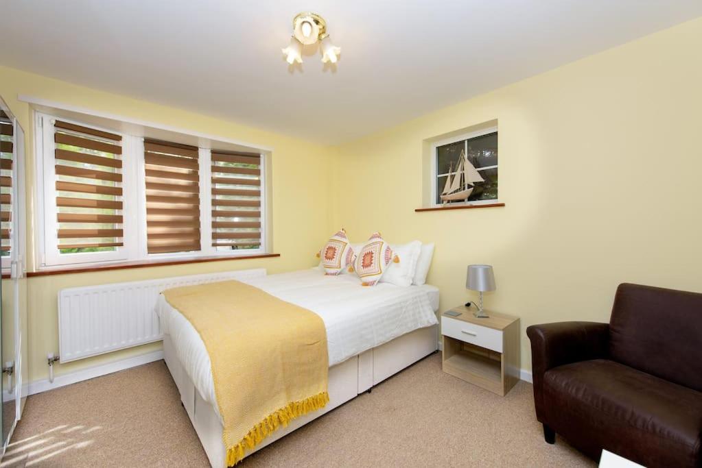 a bedroom with a white bed and a couch at Quest Fulfiller - Near hospital Free parking and Garden in Southampton