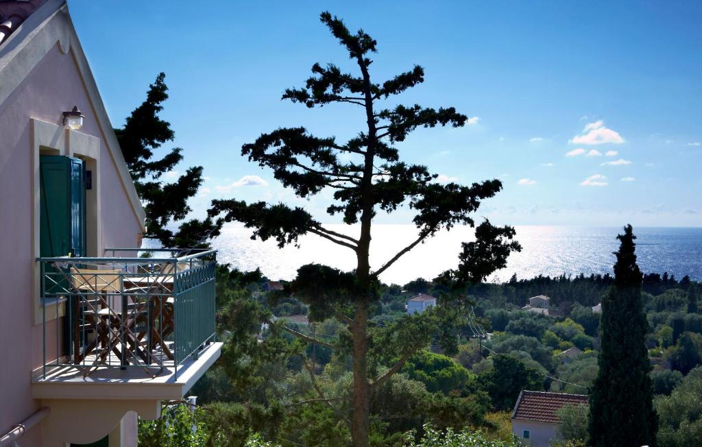 a tree on the side of a building with a view of the ocean at Dafnoudi Hotel Apartments in Fiskardo