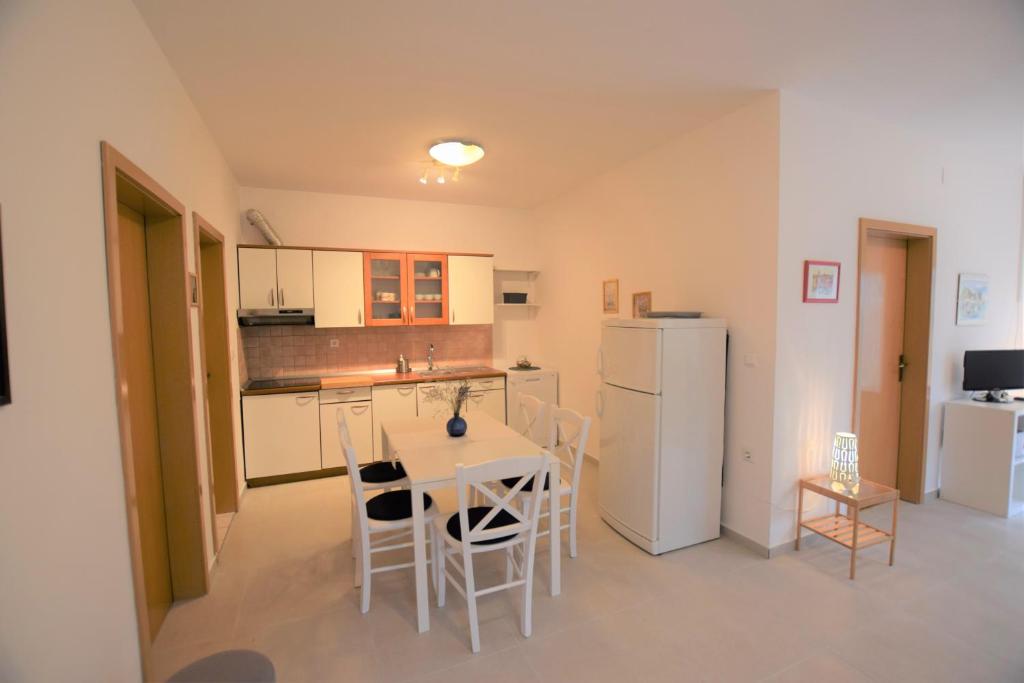kuchnia ze stołem, krzesłami i lodówką w obiekcie Holiday Home Movica w mieście Mandre