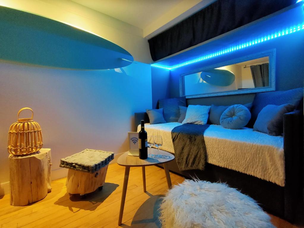 une chambre bleue avec un lit et une table dans l'établissement SURF Vue Mer 100m plage, à Berck-sur-Mer