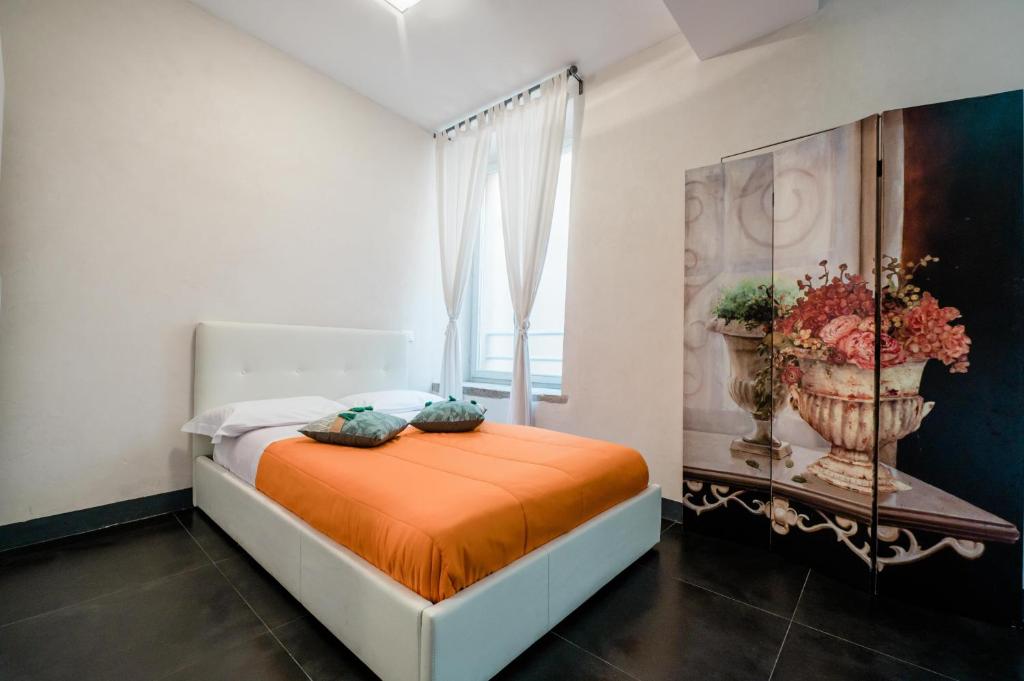um quarto com uma cama com um cobertor laranja e uma janela em FEEL - Cozy Old Town em Bérgamo