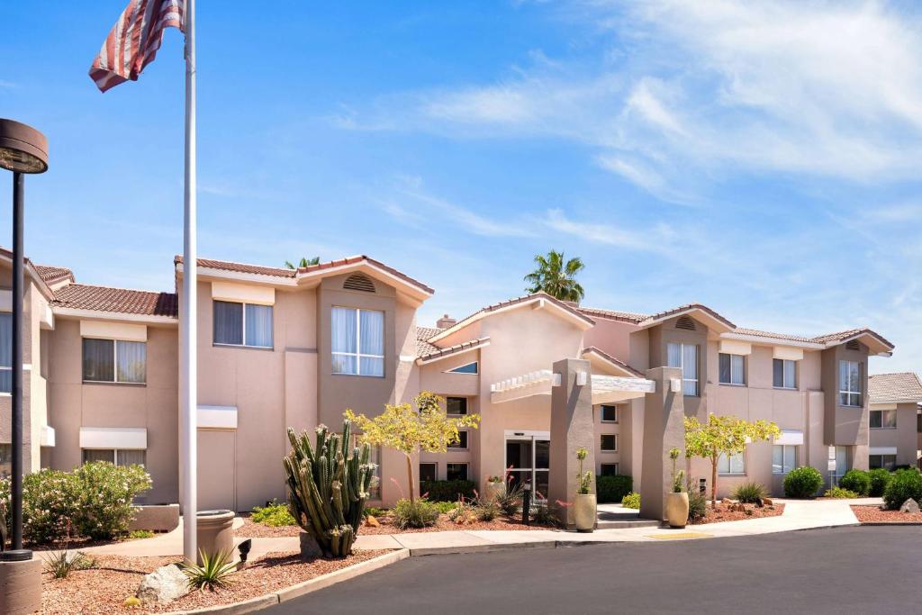 a row of apartment buildings with a flag at Sonesta ES Suites Tempe in Tempe