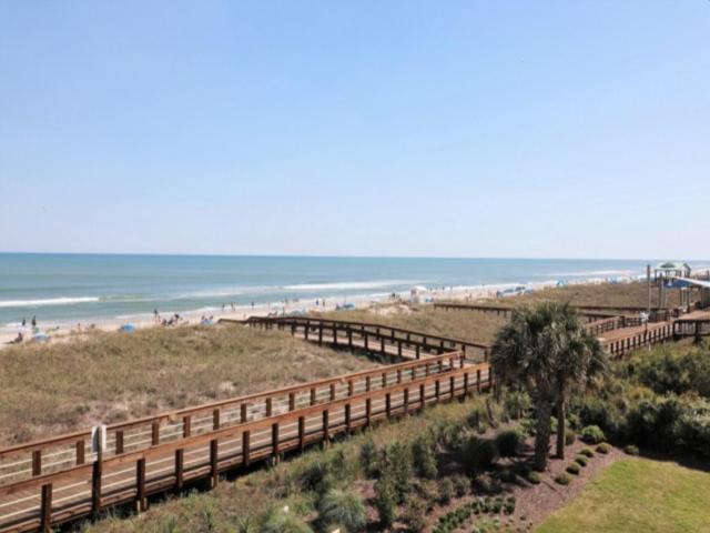 a beach with a wooden fence and the ocean at Sea Life - OCEANFRONT! Pleasure Island Paradise! Lose yourself in the ocean views! condo in Carolina Beach