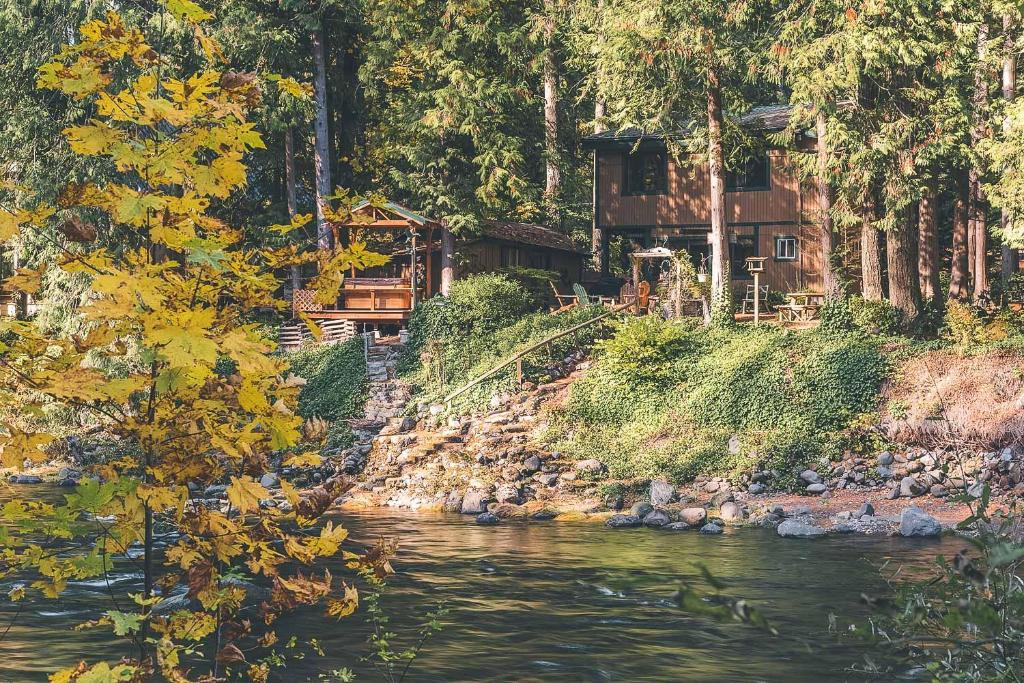 a house on a hill next to a river at Dream Catcher Cabin - Meredith Lodging in Brightwood