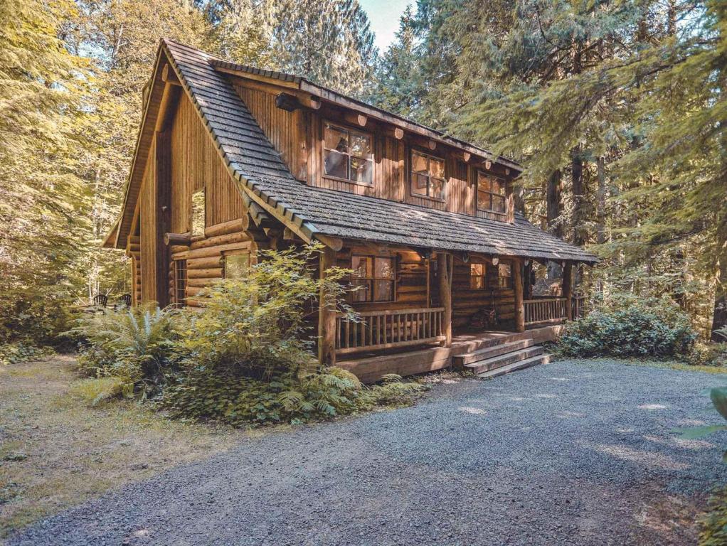 une grande cabane en bois avec une allée. dans l'établissement Bear Den Log Cabin, à Welches