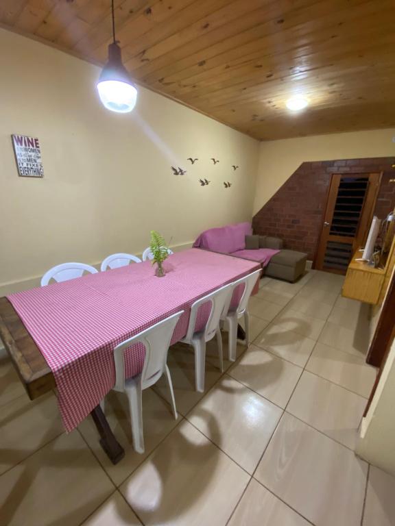 a dining room with a pink table and chairs at Chalé Bela Vista - Chalés Belo Monte in Pacoti