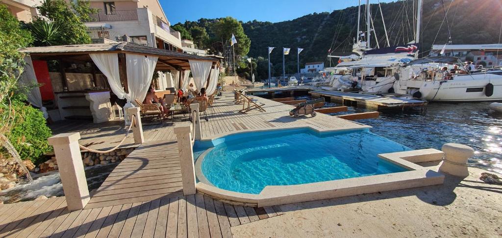 a swimming pool on a wooden deck next to a boat at Guesthouse Augusta Insula in Lastovo