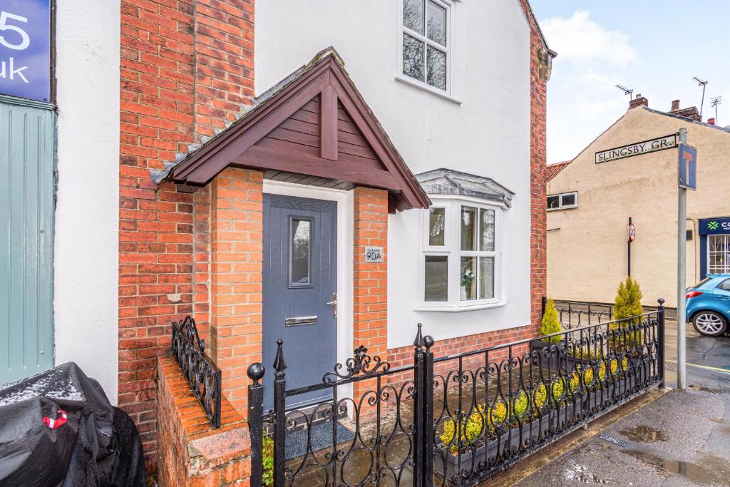 a brick house with a blue door on a street at Stablefold in York