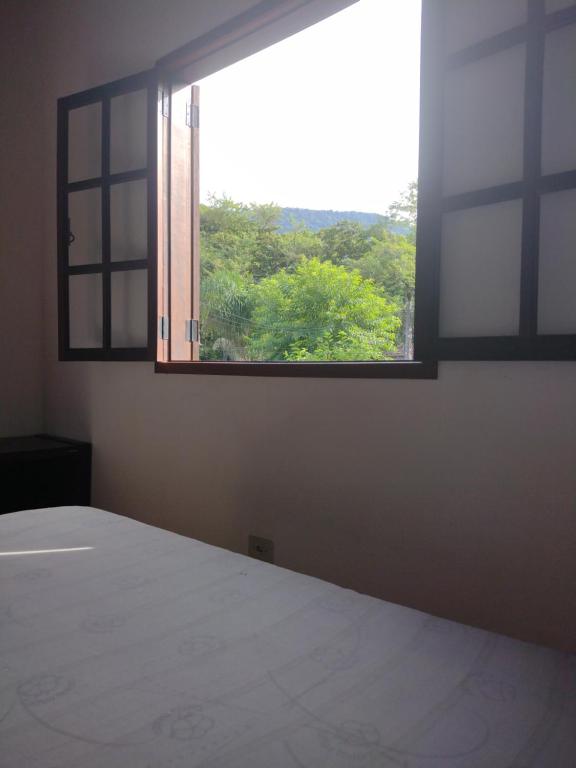 ein leeres Zimmer mit einem großen Fenster und einem Bett in der Unterkunft Casa praias de São Gonçalo em Paraty RJ in Paraty