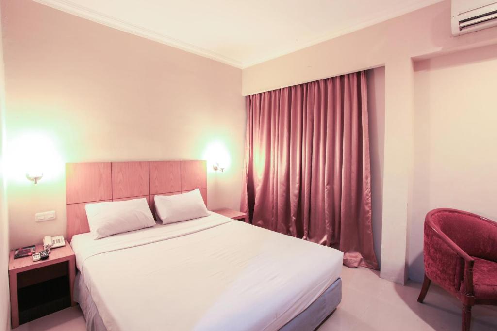 Un pat sau paturi într-o cameră la Hotel Wisata