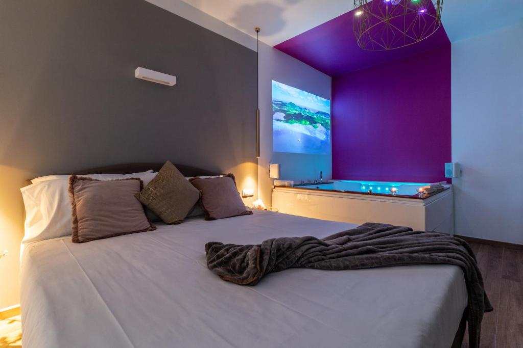 a bedroom with a large bed with a large screen at 4 Star Suite SPA - Self Check-In in Bologna