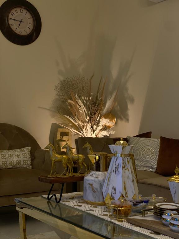 a living room with a couch and a table with a clock at ABHA GOLDEN in Abha