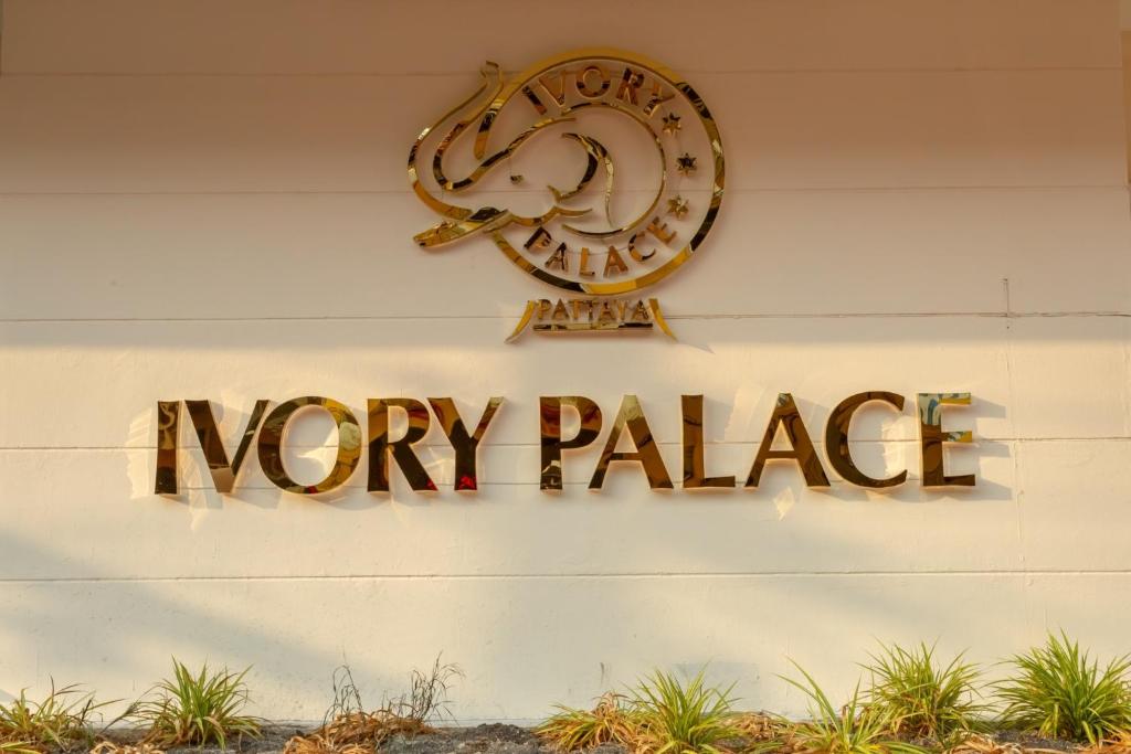 a sign that reads money palace hanging on a wall at Ivory Palace Hotel in Pattaya Central