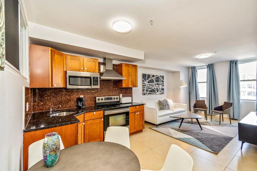 a kitchen with wooden cabinets and a living room at Forget the Hotel and stay in Style in a 2bd Apt in Philadelphia