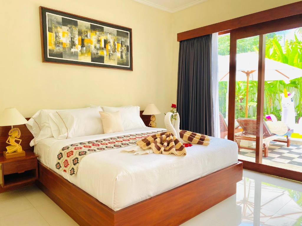 a bedroom with a bed and a balcony at Villa Serenity in Lovina